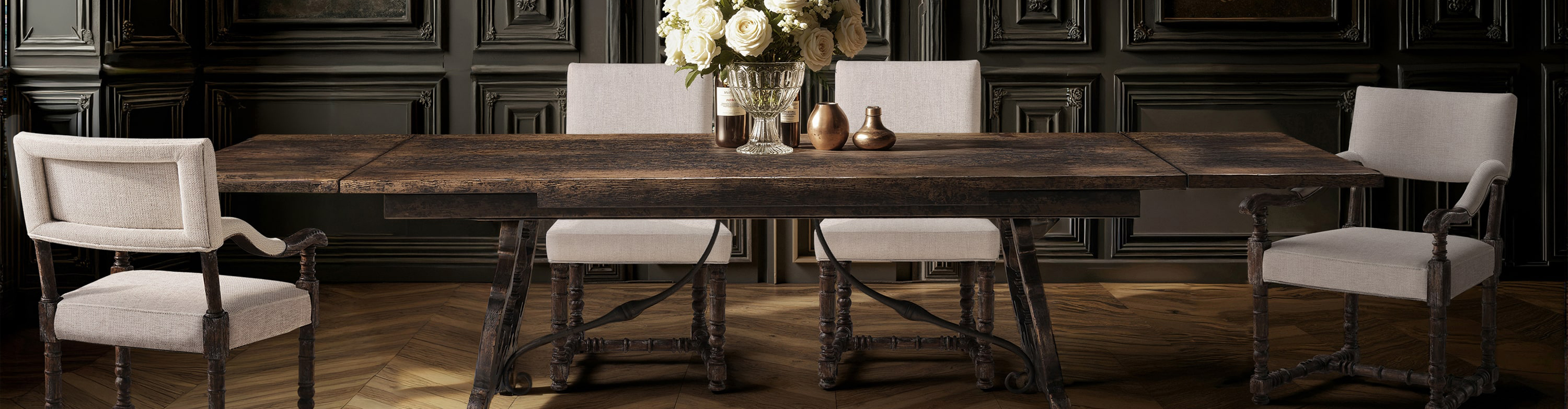 Reclaimed wood trestle dining table against dark panelled walls
